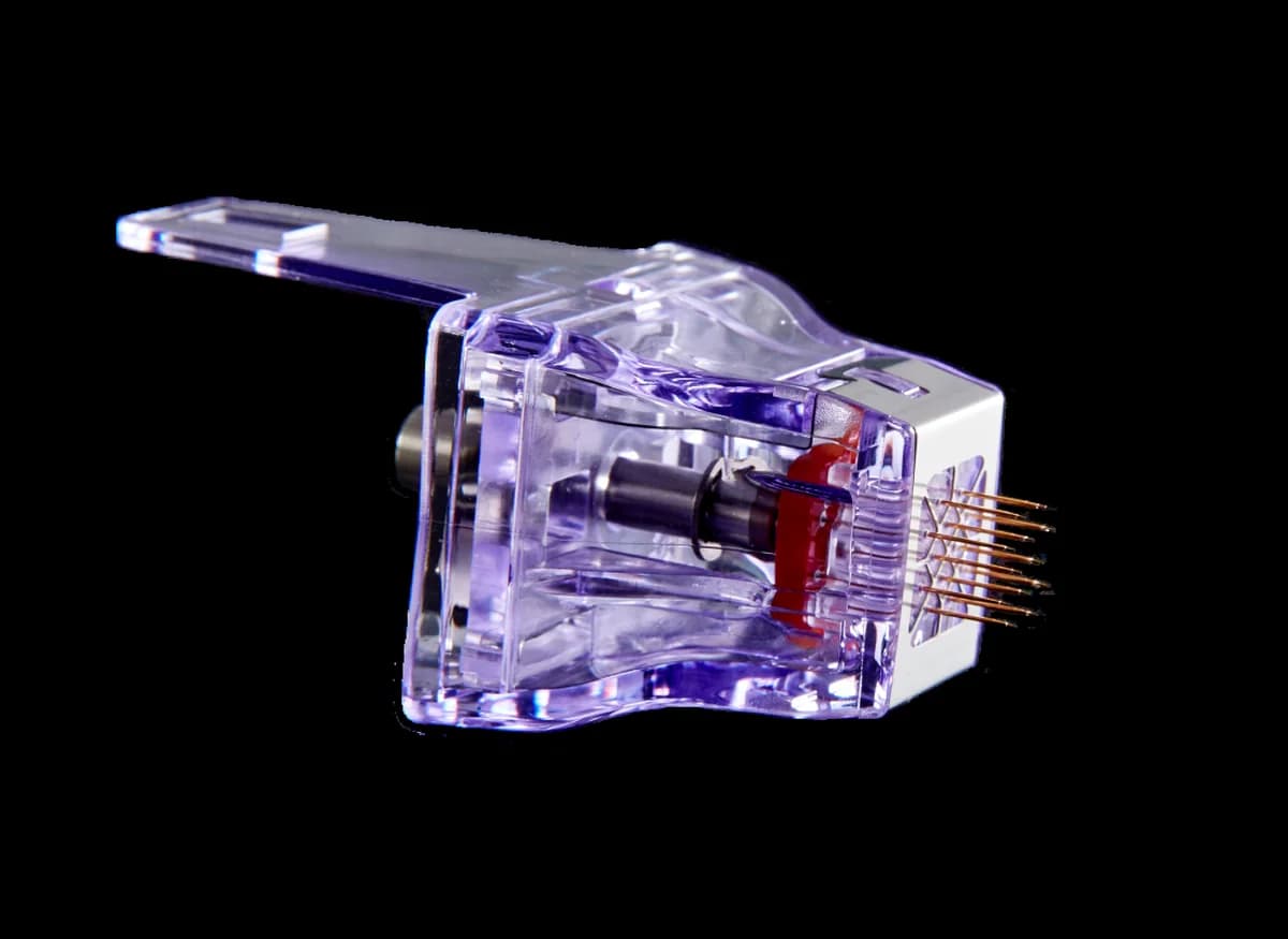 The microneedle cartridge, its gold-tipped pins facing the camera